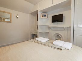 A bedroom with a bed and TV at Blowing House Cottage in Perranporth