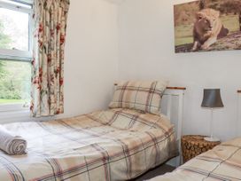 A bedroom with two beds and a window at Blowing House Cottage in Perranporth