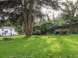 A garden with a house and tree at Blowing House Cottage in Perranporth