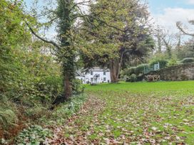 A garden with a house and trees at Blowing House Cottage in Perranporth