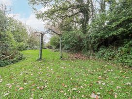 A garden with an archway and fallen leaves at Blowing House Cottage Perranporth