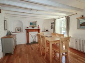 A dining room with a wooden table and chairs at Blowing House Cottage near Perranporth