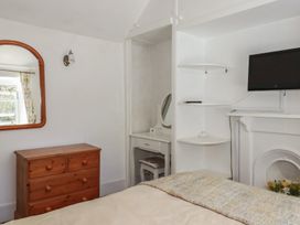 A bedroom with a mirror and chest of drawers at Blowing House Cottage near Perranporth
