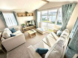 A living room with a TV and a coffee table at The Old Barn in Manchester