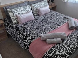 A bed with decorative pillows and towels at an unspecified location