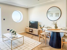 A living room with a television and dining table at The Old Barn in Manchester