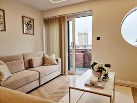 A living room with a sofa and table overlooking a balcony at the property in the location