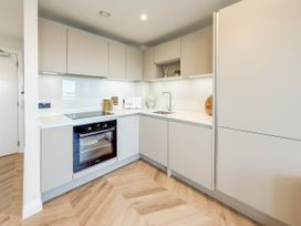 A kitchen with cabinets, sink, and oven at The Modern Flat in London
