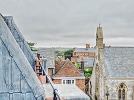 A view of rooftops and a church with hills in the background at the property in location