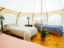 A tent interior with beds and lamps at 