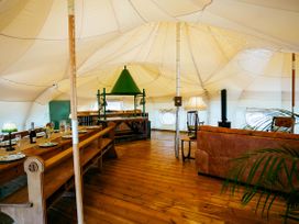 An indoor dining area with a table and chairs at a glamping tent
