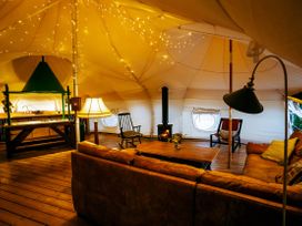 A living room with a sofa and kitchen area in a tent