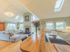 A living room with a sofa and a kitchen counter at a home in a rural area