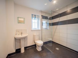 A bathroom with a shower, toilet, and washbasin at 