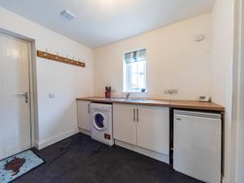 A laundry room with a washing machine and sink at The Old Barn in Manchester
