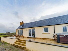An outdoor area with a house and hot tub at The Old Barn in Manchester