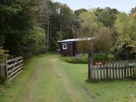 A path leading to a shed with a sign at Baillie Chalet