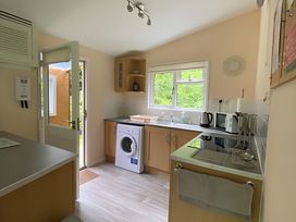 A kitchen with a washing machine and appliances at Baillie Chalet