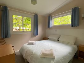 A bedroom with a bed and windows at Baillie Chalet