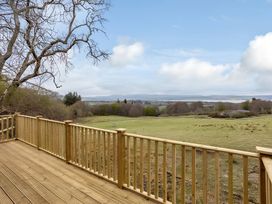 A view from a deck overlooking a grassy landscape at Kilninver Chalet