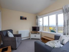 A living room with a sofa and television at Kilninver Chalet