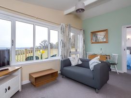 A living room with a sofa and dining table at Kilninver Chalet