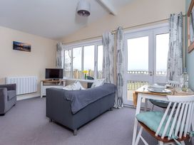 A living room with a sofa and dining table at Kilninver Chalet