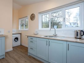 A kitchen with a washing machine and sink at Kilninver Chalet
