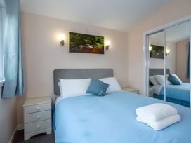 A bedroom with a bed and bedside table at Kilninver Chalet