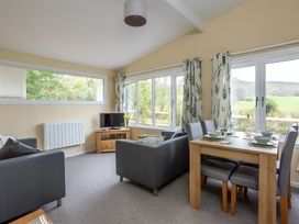A living room with a dining area and windows at The Old Barn in Manchester