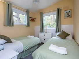 A bedroom with two beds and a lamp at The Cottage in the Woods