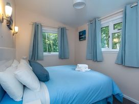 A bedroom with a bed and windows at The Old Barn in Manchester