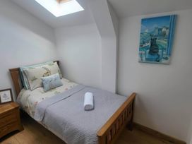 A bedroom with a bed and painting at Old Highwood Barns Dunkeswell