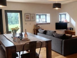 A living room with a couch and dining table at Old Highwood Barns Dunkeswell