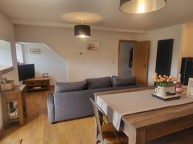 A living room with a sofa and dining table at Old Highwood Barns Dunkeswell