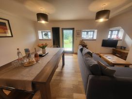 A living room with a dining table and sofa at Old Highwood Barns in Dunkeswell
