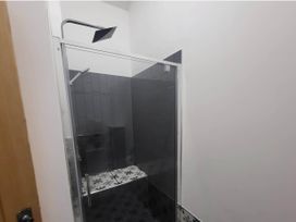 A shower area with glass door and tiled walls at Old Highwood Barns in Dunkeswell