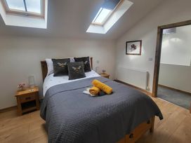 A bedroom with a bed and nightstand at Old Highwood Barns, Dunkeswell