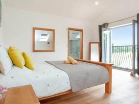 A bedroom with a bed and door leading to a balcony at the property