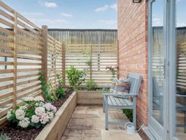 A garden with a bench and flowers in planters at The Old Barn in Manchester