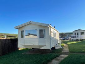 A mobile home with a pathway and steps at a holiday park