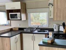 A kitchen with a microwave, sink, kettle, and toaster at a property in an unspecified location