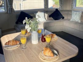 A living room with a table set for breakfast at a holiday home in unspecified location