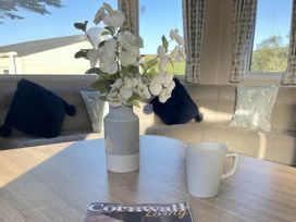 A living room with a coffee mug and magazine on the table at 