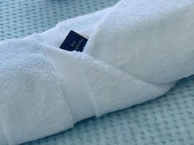 A towel with a tag on a blue blanket in a bedroom