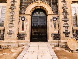 An entrance with a black door and stone walls at Capel Llani in Llanidloes