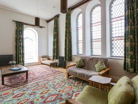 A living room with a table and sofas at Capel Llani Llanidloes