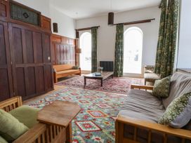 A living room with a sofa, armchair, and coffee table at Capel Llani Llanidloes