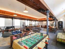 A living room with a foosball table and piano at Capel Llani in Llanidloes