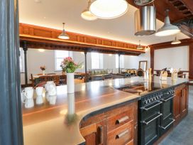 A kitchen with a dining area and a kitchen island at Capel Llani Llanidloes